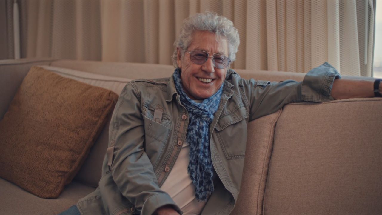 Roger Daltry smiling on a couch